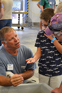 VIMS Eastern Shore Lab Watercraft Operations Manager Sean Fate answers questions at a touch tank. Photo by Susan Maples/VIMS.