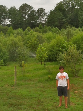 Governor's School student Elliott Theuerkauf in front of his study site in New Kent County. Photo by Wes Hudson.